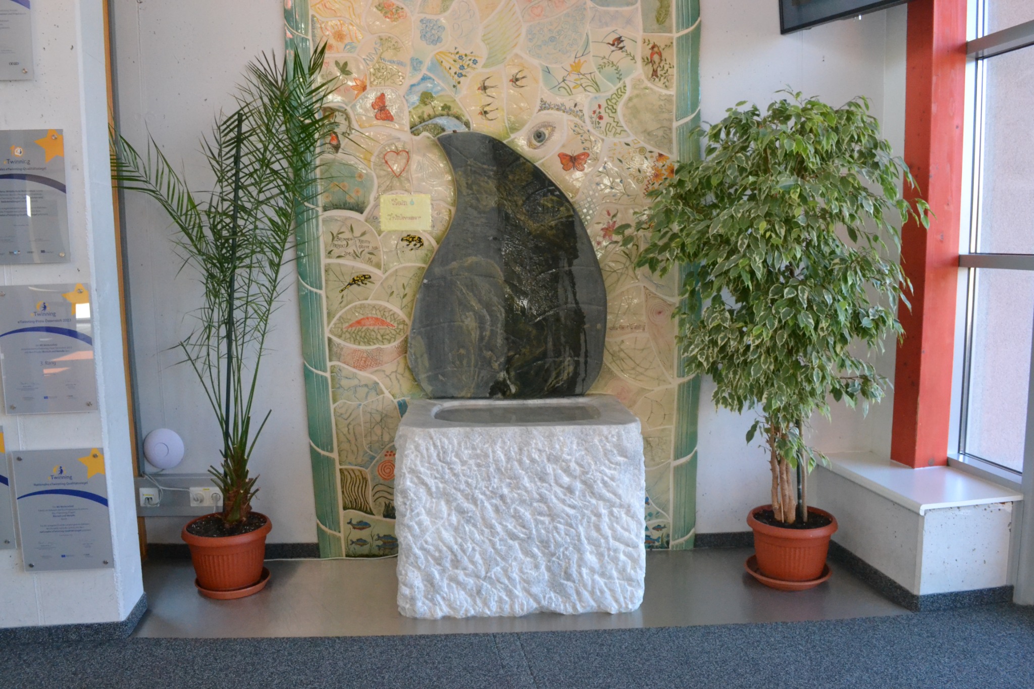 Künstlerisch gestalteter Brunnen in der Mittelschule